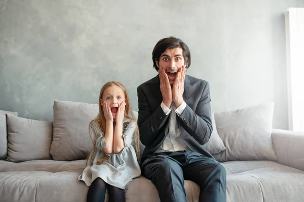 Vader en dochter kijken allebei geschokt iets — Stockfoto