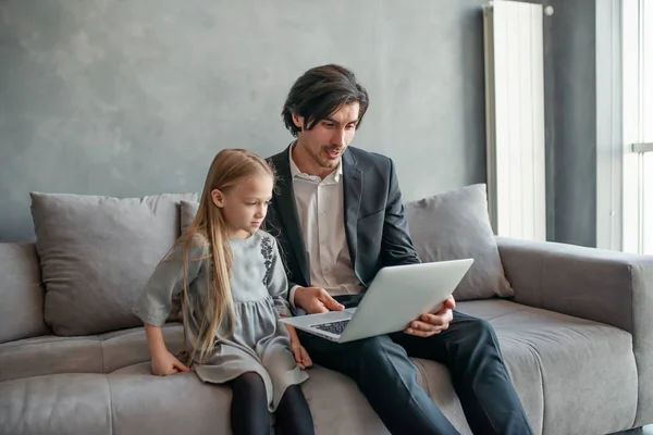 Gelukkig klein meisje kijken naar een film op de computer met haar vader — Stockfoto