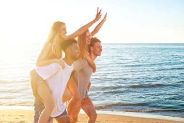 Mutlu gülümseyerek kumsalda oynarken çiftler