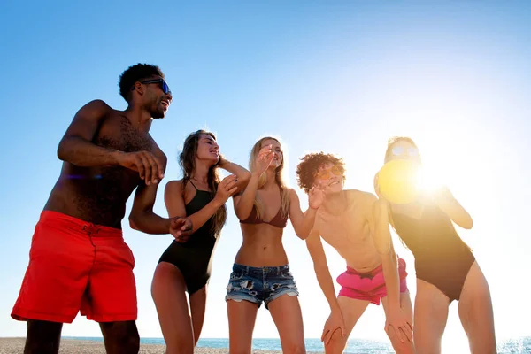 Grupo de amigos felices divirtiéndose en la playa del océano al amanecer — Foto de Stock