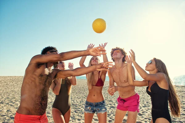 Plaj voleybolu kumsalda oynarken arkadaş grubu — Stok fotoğraf