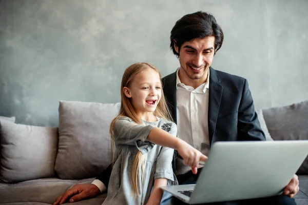 Gelukkig klein meisje kijken naar een film op de computer met haar vader — Stockfoto