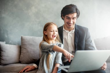 Mutlu küçük kız babası ile bilgisayarda bir film izlerken