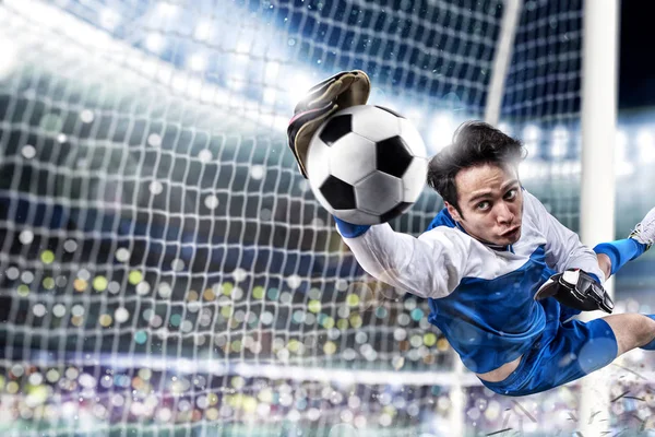 Gardien de but attrape le ballon dans le stade lors d'un match de football. — Photo