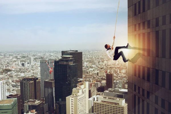 El hombre de negocios sube a un edificio con una cuerda. Concepto de determinación —  Fotos de Stock
