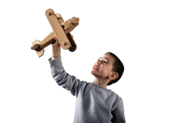 Il ragazzo gioca con un aeroplano giocattolo di legno. Isolato su sfondo bianco — Foto Stock