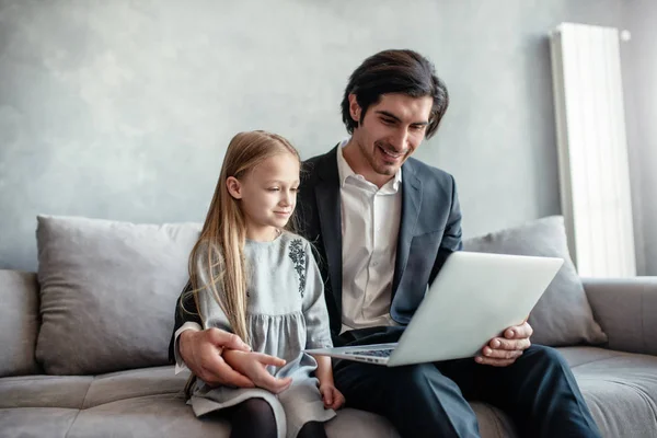 Gelukkig klein meisje kijken naar een film op de computer met haar vader — Stockfoto