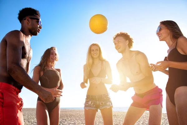 Grupa przyjaciół, grając w siatkówkę na plaży — Zdjęcie stockowe