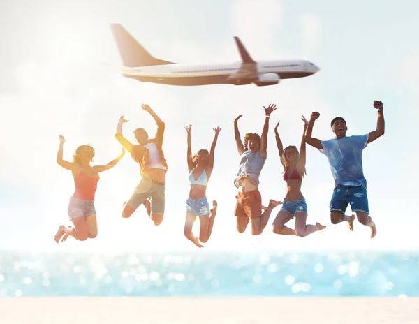 Happy smiling couples playing at the beach with aircraft in the sky — Stock Photo, Image