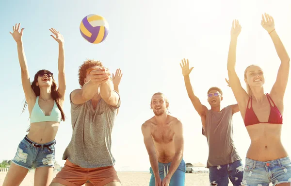 Grupo de amigos jugando al voleibol en la playa — Foto de Stock