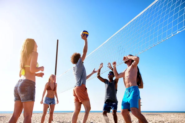 Grupo de amigos jugando al voleibol en la playa — Foto de Stock