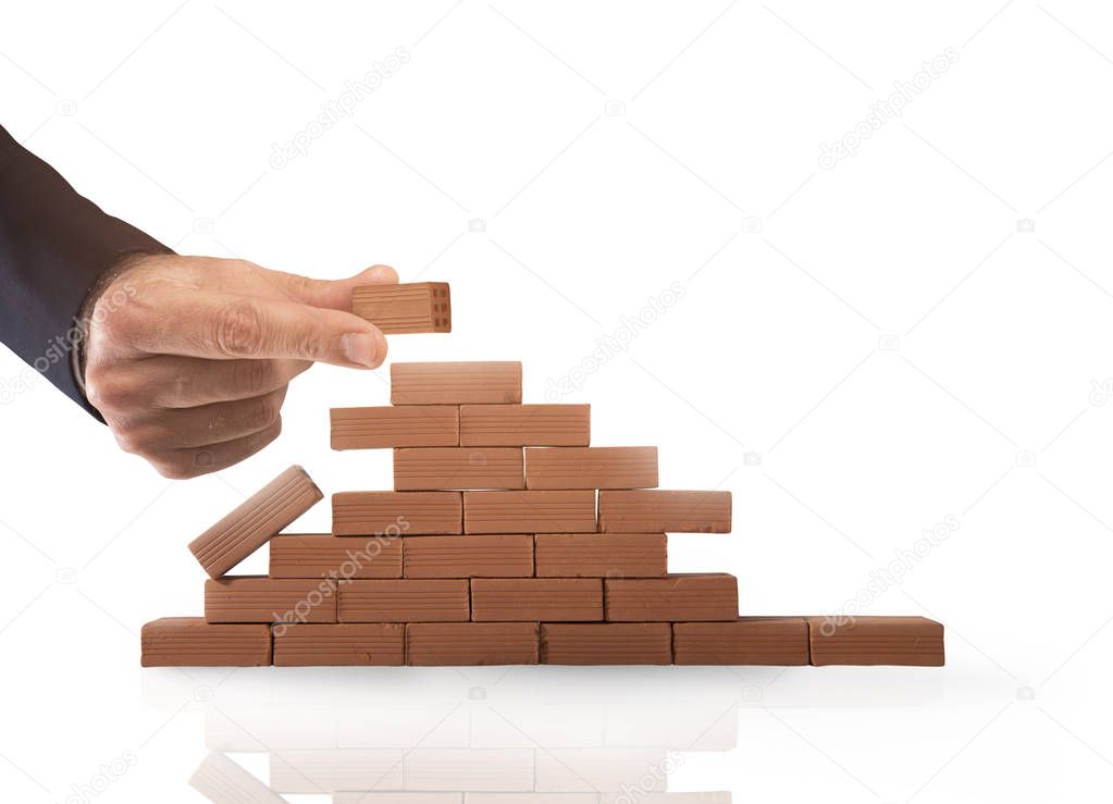 Businessman puts a brick to build a wall. Concept of new business, partnership, integration and startup