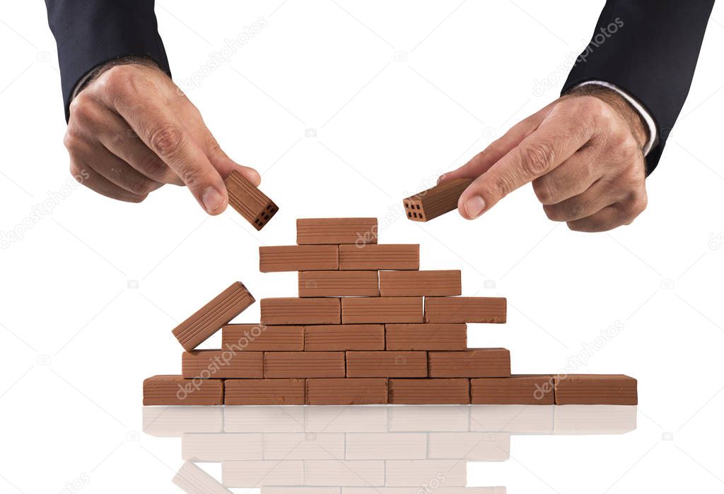 Businessman puts a brick to build a wall. Concept of new business, partnership, integration and startup