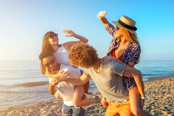 Szczęśliwy uśmiechający się pary, gra na plaży — Zdjęcie stockowe