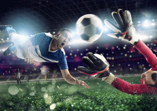 Вратарь ловит мяч на стадионе во время футбольного матча.