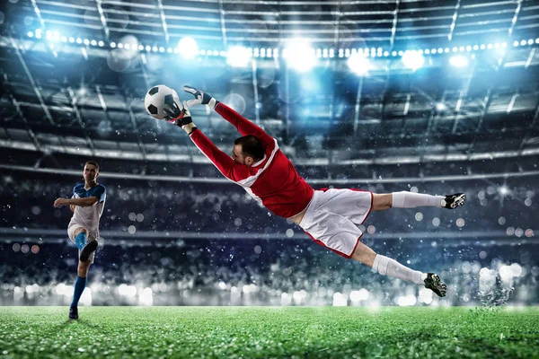 Вратарь ловит мяч на стадионе во время футбольного матча. — стоковое фото