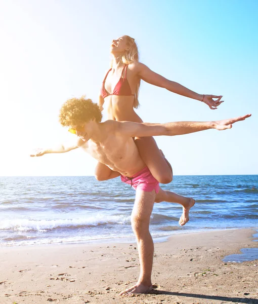 Szczęśliwy uśmiechający się pary, gra na plaży — Zdjęcie stockowe