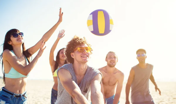 Grupo de amigos jugando al voleibol en la playa — Foto de Stock