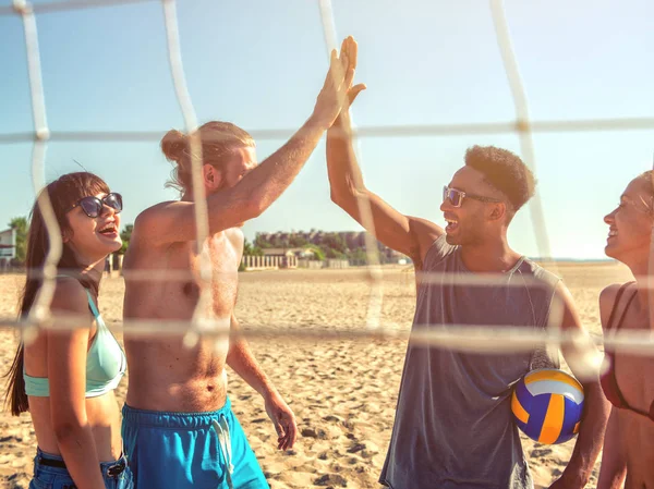 Grupo de amigos jugando al voleibol en la playa — Foto de Stock