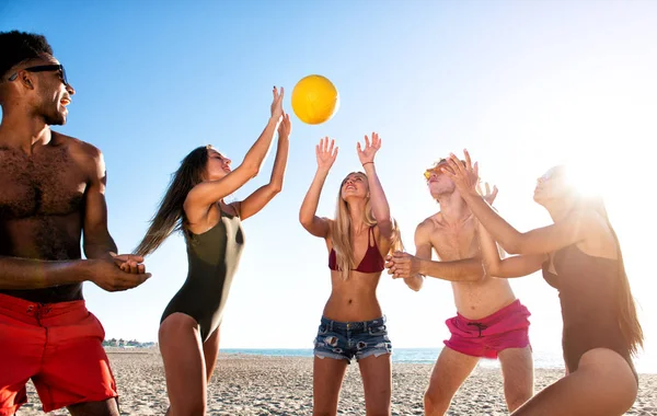 Grupo de amigos jugando al voleibol en la playa — Foto de Stock