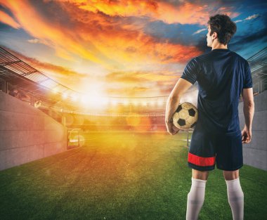 Futbol oyuncusu soyunma odası tüneli çıkışında elinde topu ile oynamaya hazır
