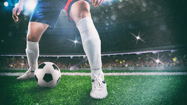 Primer plano de un jugador de fútbol sosteniendo la pelota para un goteo en el estadio durante el partido de noche —  Fotos de Stock
