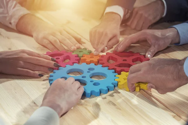 El equipo de negocios conecta piezas de engranajes. Trabajo en equipo, asociación e integración — Foto de Stock