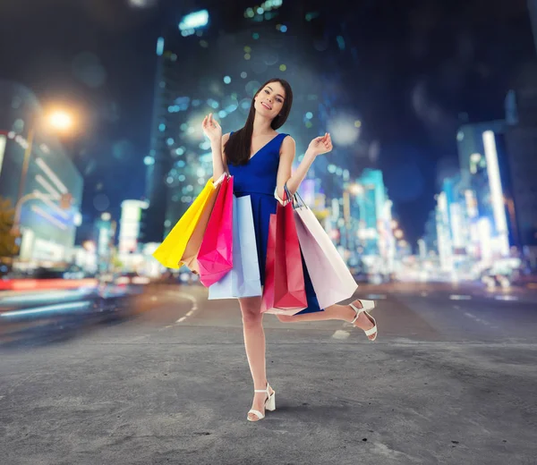 Frau mit Einkaufstaschen in der Hand spaziert durch die Stadt — Stockfoto