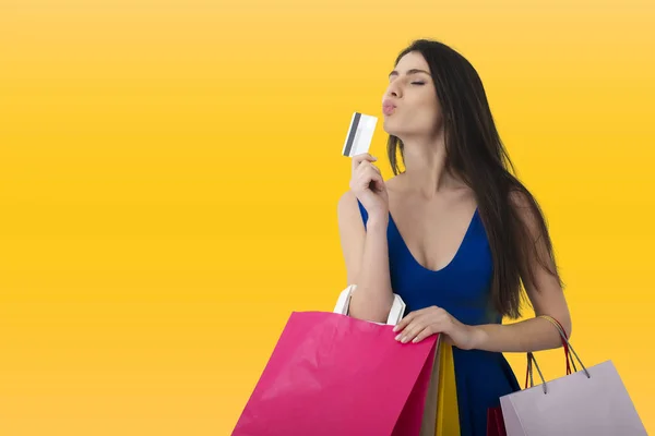 Szczęśliwa kobieta z torby na zakupy w ręku i z jej karty kredytowej. — Zdjęcie stockowe