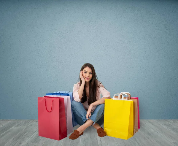 Mujer feliz con las niñas con bolsas después de comprar —  Fotos de Stock