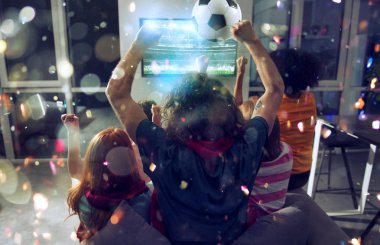 Futbolseverlerin mutlu arkadaşları televizyonda futbol izliyor ve düşen konfeti ile zaferi kutluyorlar. Çift pozlama