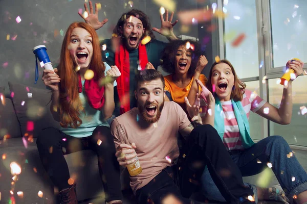 Happy friends of football fans watching soccer on tv and celebrating victory with falling confetti. — Stock Photo, Image