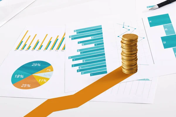 Pile de pièces d'or sur les feuilles statistiques. Concept de croissance des investissements financiers — Photo