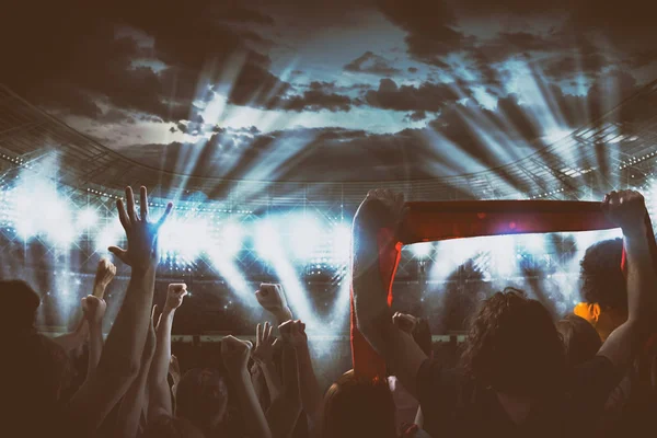 Éjszakai rendezvény a rajongók mámoros a stadionban egy élő koncert a fényszóró — Stock Fotó