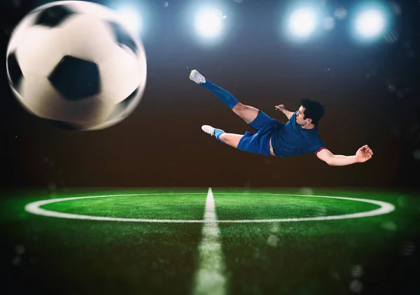 Scena piłki nożnej w nocy meczu z graczem kopiąc piłkę z mocą — Zdjęcie stockowe