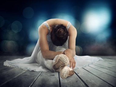 Tiyatro sahnesinde uzanan klasik dansçı