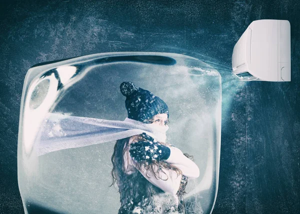 Mujer congelada en un cubo de hielo bajo el chorro de aire de un aire acondicionado — Foto de Stock