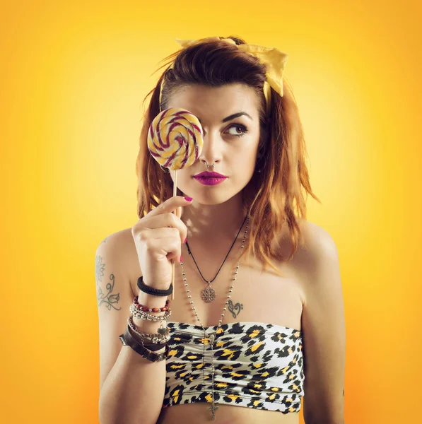 Jovem mulher comendo pirulito em estilo amarelo — Fotografia de Stock