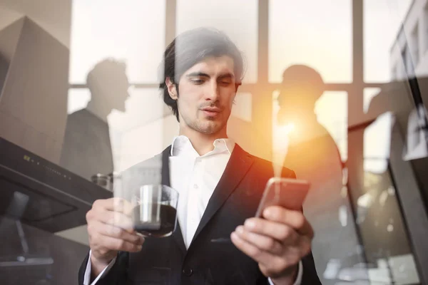 El hombre de negocios trabaja con su smartphone en la oficina. doble exposición . —  Fotos de Stock