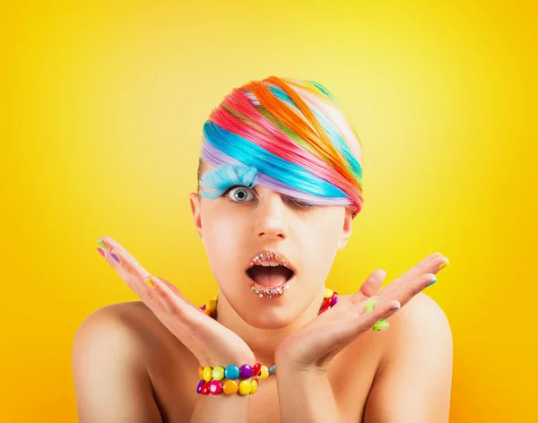 黄色の背景に虹のカラフルなファッションメイクを持つ女の子 — ストック写真
