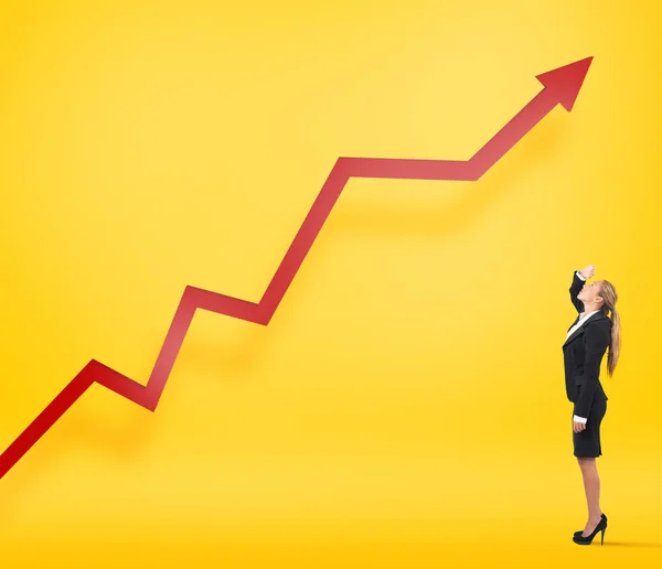 Businesswoman watches her company statistic grow up. Yellow background — Stock Photo, Image