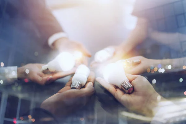 Trabalho em equipe e conceito de brainstorming com empresários que compartilham uma ideia com uma lâmpada. Conceito de inicialização — Fotografia de Stock