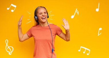Sarışın kız kulaklıkla müzik dinliyor. Sarı arka planda neşeli ifade