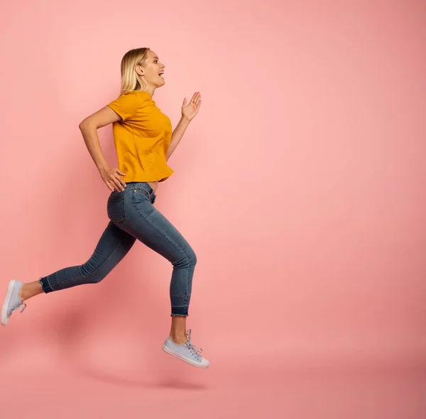 La chica corre rápido. Concepto de energía y vitalidad. Fondo rosa —  Fotos de Stock