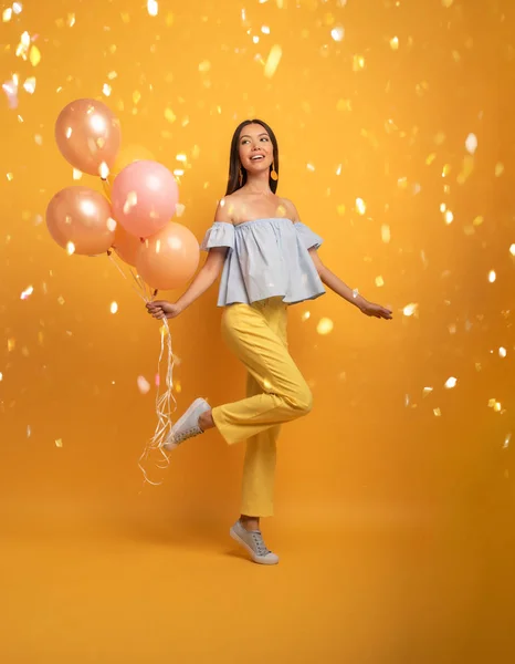 Chica lista para una fiesta con globo. Alegre expresión de felicidad. Fondo amarillo — Foto de Stock