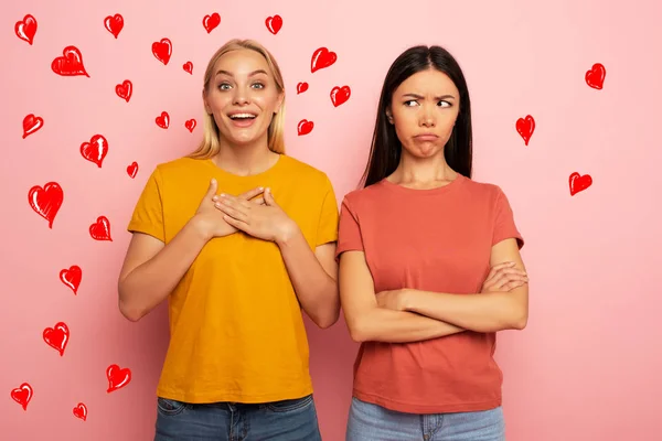 Vrienden ontvangt likes en harten van sociale netwerk. Maar de blonde is gelukkig en de brunette is dat niet. Roze achtergrond — Stockfoto