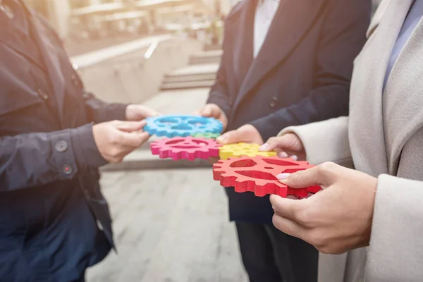 Zakenteam verbinden stukken tandwielen. Teamwork, partnerschap en integratie — Stockfoto