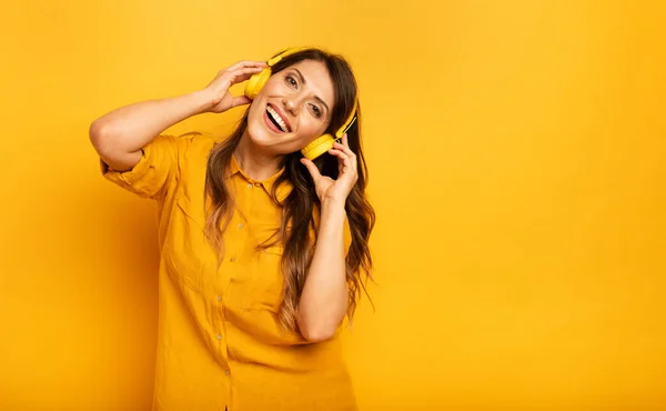 Mädchen mit gelbem Headset hören Musik und tanzen. emotionaler und energetischer Ausdruck — Stockfoto