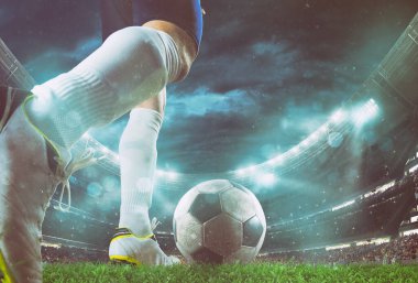 Gece futbol sahnesinin perspektifini kapat. Futbolcu topa vuruyor.