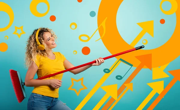 Las chicas con auriculares usan la escoba como una guitarra. Antecedentes cian — Foto de Stock